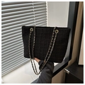 Gros plan du sac cabas en tweed noir avec motif quadrillé et chaîne dorée - Noir
