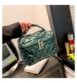 Détail d'une trousse de maquillage matelassée vert foncé métallisé avec fermetures éclair dorées - Vert
