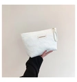 Dettaglio della borsa trucco bianca trapuntata con cuori, perle e etichetta moda - Bianco