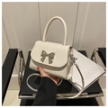 Dettaglio borsa bianca con fiocco in metallo argentato e chiusura a patta magnetica - Bianco