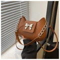Dettaglio di una borsa in pelle marrone con fibbia a fiocco in argento e catenella - Marrone