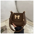 Brown vintage faux leather saddle bag featuring a gold bow accent and knotted handle strap - Brown