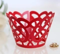 Detail van rode lasergesneden cupcake wikkel met verfijnd hartjes- en spiraalpatroon - Parelrood