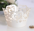 Macro shot of white laser-cut cupcake wrapper with heart patterns and elegant lace - Ivory