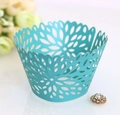 Macro detail of laser-cut cupcake wrapper with floral pattern and scalloped top edge - Tiffany Blue