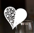 Dettaglio macro di un segnaposto a cuore intagliato al laser sul bordo di un bicchiere - Bianco