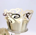 Macroshot van lasergesneden champagne gouden cupcake wrappers met hartjes patroon - Reflecterend Zilver
