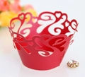 Macro-opname van rode lasergesneden cupcake wrappers met hartjes en krullende patronen - Parelrood