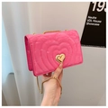 Detail der pinkfarbenen gesteppten Tasche mit Herzmuster und goldenem Drehverschluss - Rosarot