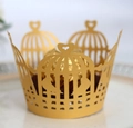 Macro shot of gold laser-cut cupcake wrapper with crown and heart design details - Gold
