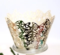 Macro detail of laser-cut butterfly pattern on golden cupcake wrapper decorative sleeve - Reflective Silver