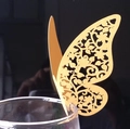 Vue macro d'un marque-place papillon doré découpé au laser pour verre de mariage - Doré