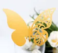 Detailed laser-cut gold butterfly place card with floral patterns on a wine glass rim - Gold