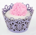 Macro shot of purple laser-cut cupcake wrapper with butterfly patterns on frosting cake - Light Purple