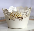 Close-up of laser-cut white pearl paper cupcake wrapper with elegant rose patterns - 5cm / Ivory