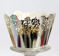 Detail of silver laser-cut cupcake wrapper with intricate hollow floral patterns and mirror finish - Reflective Silver