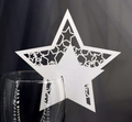 Macro detail of white star-shaped laser-cut wine glass place card for wedding decor - White