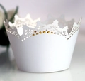 Detail showing white laser-cut crown lace cupcake wrappers for weddings and parties - White