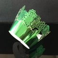 Macro detail of laser-cut green metallic lace cupcake wrapper with floral patterns - Reflective Green