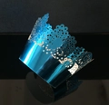 Detail of royal blue laser-cut lace cupcake wrappers with elegant crown patterns - Reflective Blue