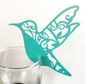 Detail of laser-cut hummingbird paper card in teal blue on a wine glass rim - Tiffany Blue