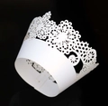 Detail of laser-cut floral crown patterns on white lace cupcake paper wrappers - White