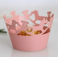 Pink laser-cut cupcake wrappers with rocking horse and bear patterns for party - Pink