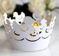 Detailed laser cut white cupcake wrapper with duck pattern holding gold foil candy - White