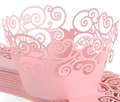Macro detail of laser-cut pink cupcake wrappers with elegant scrollwork hollow patterns - Pink