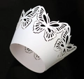 Macro detail of laser-cut butterfly patterns on white pearlescent cupcake wrappers - White