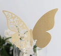 Makroaufnahme einer goldglitzernden Laserschnitt-Schmetterlingskarte für Weinglas - Beige Gold