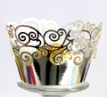 Macro view of silver laser-cut cupcake wrappers with elegant scroll patterns - Reflective Silver