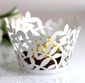 Elegant laser-cut white paper cupcake wrappers with intricate floral leaf patterns - White