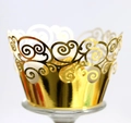 Macro view of golden laser-cut cupcake wrapper with elegant spiral filigree patterns - Reflective Gold