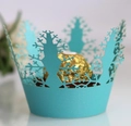 Detail of laser-cut turquoise cupcake wrapper with festive snowflake and tree patterns - Tiffany Blue
