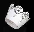 Macro shot of white laser-cut cupcake wrappers with elegant crown pattern for party decor - White