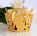 Detail view of gold laser-cut wedding cupcake wrappers with bride and groom silhouette - Gold