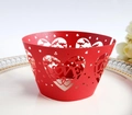 Nahaufnahme lasergeschnittener roter Herz-Cupcake-Förmchen mit LOVE-Design auf Teller - Perlrot