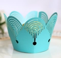 Macro shot of laser-cut mint blue cupcake wrappers featuring elegant hollow arch designs - Tiffany Blue