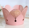 Detail of laser-cut pink crown cupcake wrapper with intricate hollowed patterns - Pink