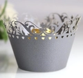 Macro view of laser-cut silver cupcake wrapper with ornate vine patterns and heart details - Silver Charcoal