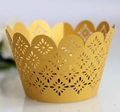 Close-up of golden laser-cut cupcake wrappers with intricate hollow star pattern and wavy edge - Gold