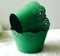 Close-up of green laser-cut cupcake wrappers featuring elegant rose flower patterns - Dark Green