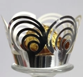 Macro view of silver laser-cut crown lace cupcake wrapper with a golden chocolate - Reflective Silver