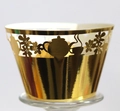 Macro detail of laser-cut golden mirror cupcake wrapper with elegant teapot motif - Reflective Gold