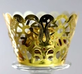 Elegant gold laser-cut cupcake wrappers with floral lace patterns on a glass stand - Reflective Gold