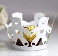 Macro detail of laser-cut white cardstock cupcake wrappers with bear and heart patterns - White