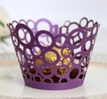Detail of laser-cut dark purple cupcake wrapper with circle pattern on a ceramic plate - Dark Purple
