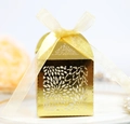 Detailed view of golden laser-cut hollow floral candy box with an elegant ribbon bow - Reflective Gold