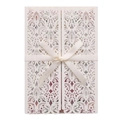 Detail of cream laser-cut wedding invitation with lace pattern and silk ribbon bow - Ivory